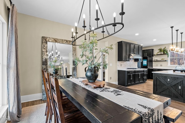 dining area featuring an inviting chandelier, recessed lighting, baseboards, and light wood finished floors