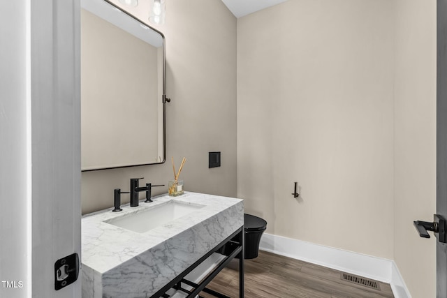 bathroom with vanity, wood finished floors, visible vents, baseboards, and toilet