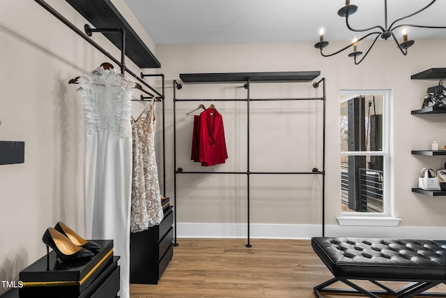 spacious closet with a notable chandelier and wood finished floors