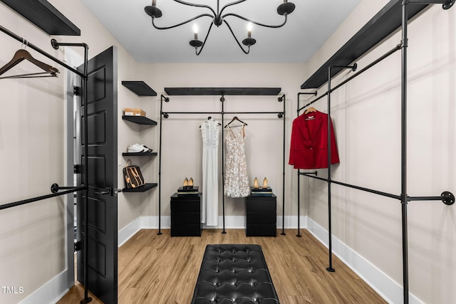 walk in closet featuring a notable chandelier and wood finished floors