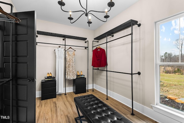 spacious closet featuring a chandelier and wood finished floors