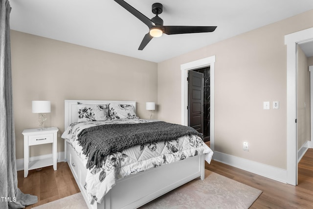 bedroom featuring ceiling fan, baseboards, and wood finished floors