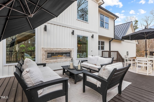 wooden deck featuring outdoor dining space and an outdoor living space with a fireplace