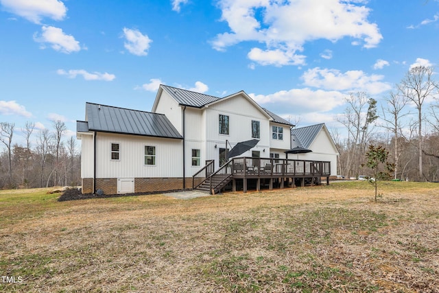 back of property with metal roof, a yard, a deck, and a standing seam roof