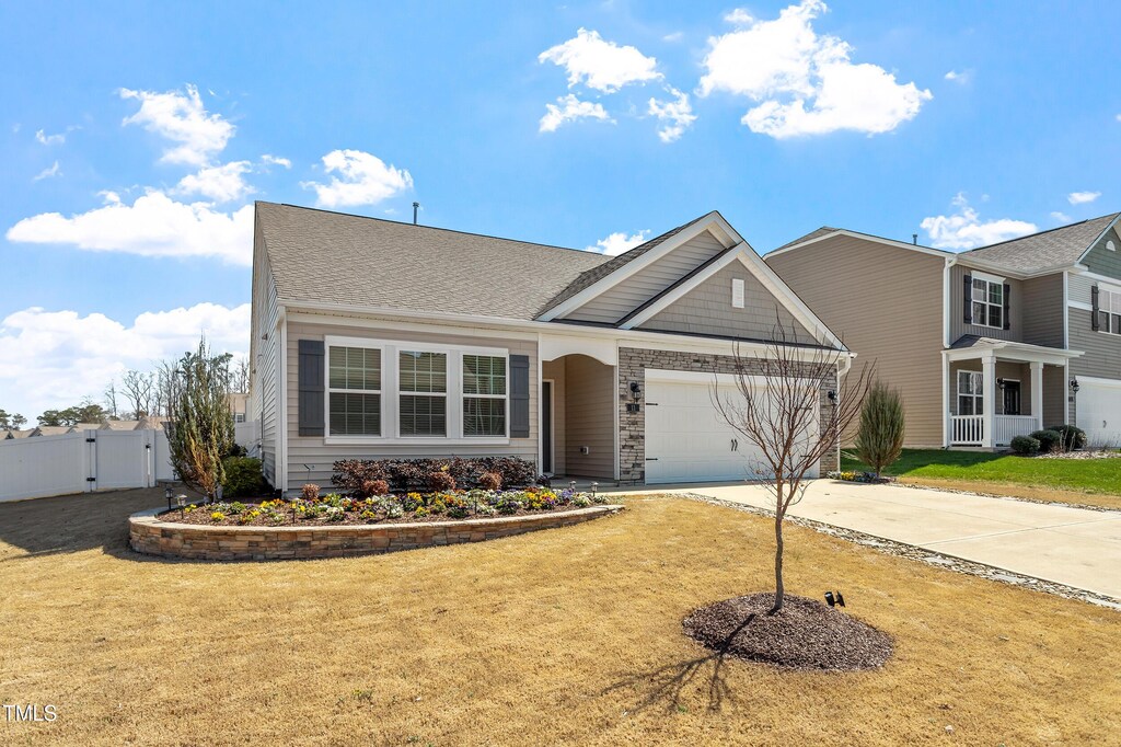view of front of house with a garage, a front yard, driveway, and a gate