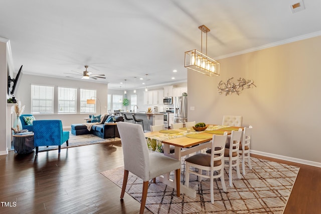 dining room featuring wood finished floors, baseboards, recessed lighting, ceiling fan, and crown molding