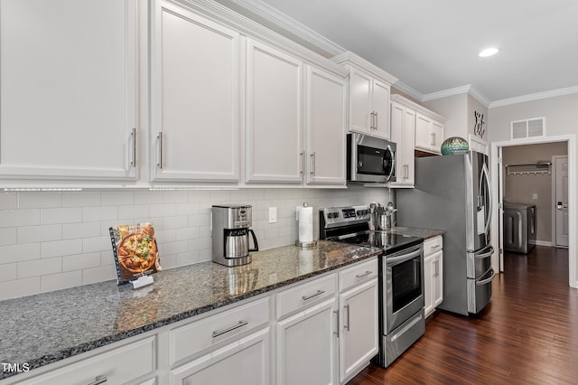 kitchen with visible vents, dark wood finished floors, stainless steel appliances, white cabinetry, and crown molding