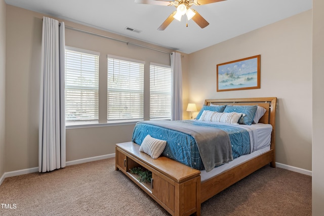 bedroom featuring visible vents, light colored carpet, baseboards, and ceiling fan