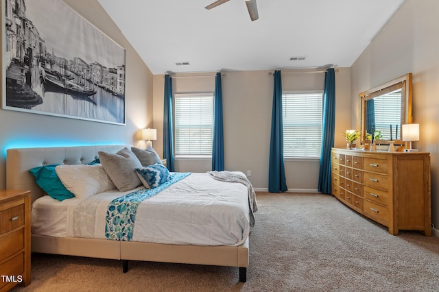 carpeted bedroom with visible vents, multiple windows, and lofted ceiling