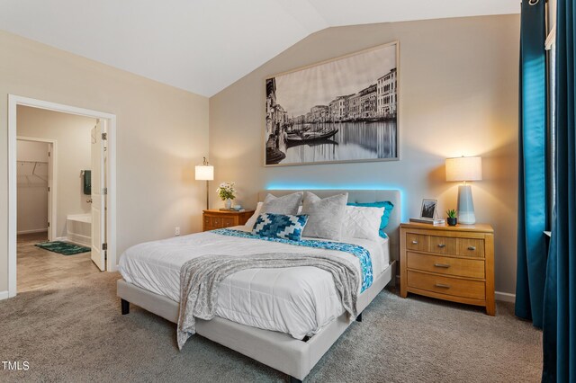 carpeted bedroom with baseboards, lofted ceiling, and ensuite bathroom