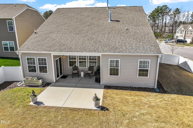 rear view of property with a patio area, a fenced backyard, a yard, and roof with shingles