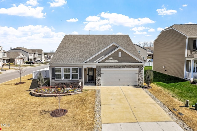 view of front of house with a front lawn, stone siding, a garage, and driveway