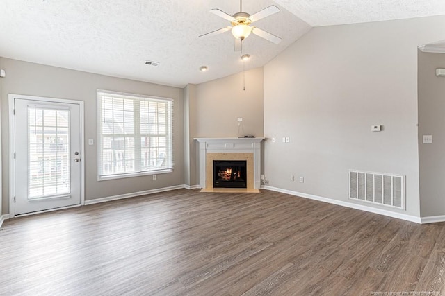 unfurnished living room featuring visible vents, a textured ceiling, wood finished floors, lofted ceiling, and ceiling fan