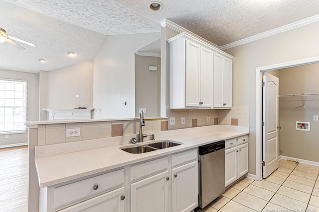 kitchen with dishwasher, light countertops, decorative backsplash, white cabinetry, and a sink