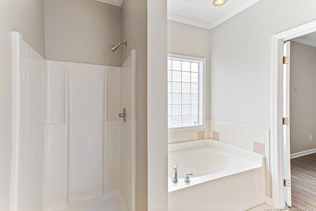 full bathroom featuring wood finished floors, a bath, a stall shower, and ornamental molding