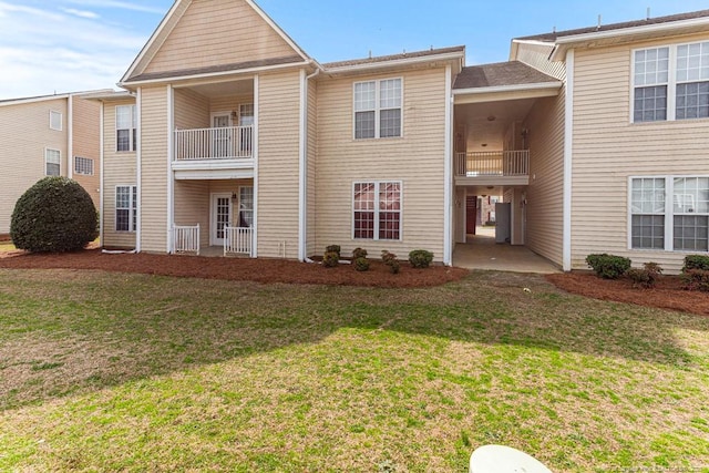 exterior space featuring a balcony and a front lawn