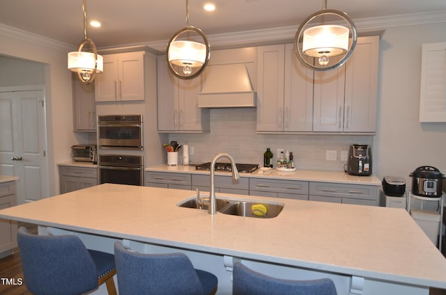 kitchen featuring a sink, gray cabinets, decorative backsplash, and premium range hood