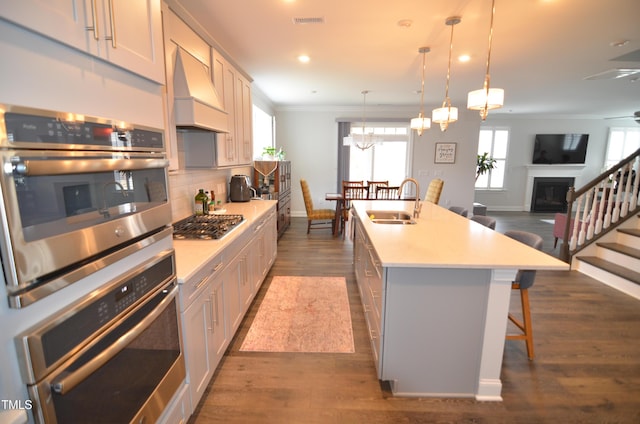 kitchen featuring visible vents, backsplash, light countertops, stainless steel appliances, and a sink