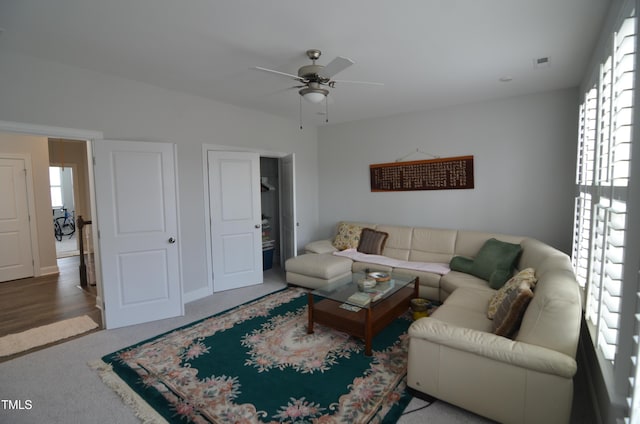 carpeted living room featuring a ceiling fan and visible vents