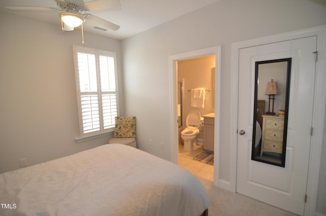 bedroom with light carpet, visible vents, ensuite bathroom, and ceiling fan