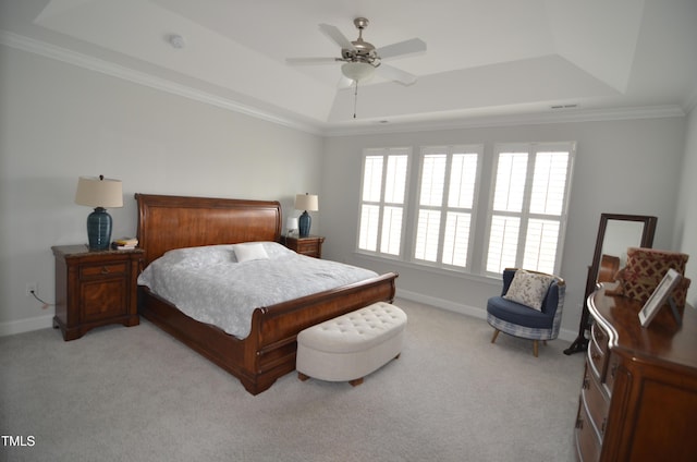 bedroom featuring light colored carpet, baseboards, crown molding, and a tray ceiling