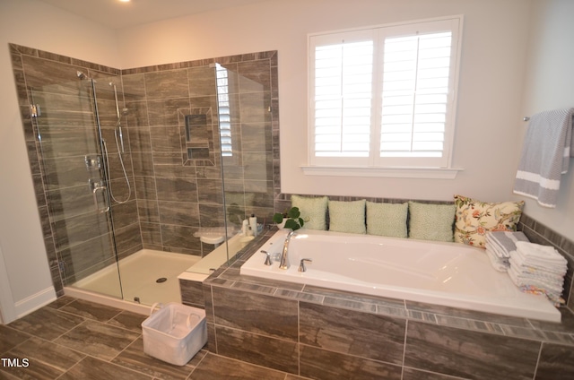 full bathroom featuring a shower stall and a garden tub