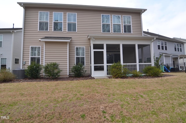 back of house with central air condition unit, a lawn, and a sunroom