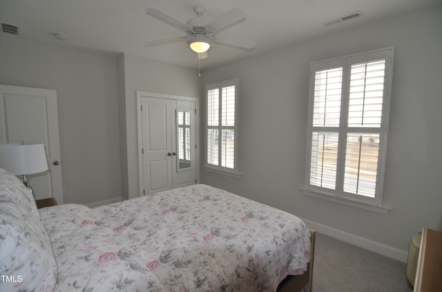 carpeted bedroom featuring visible vents, baseboards, a closet, and a ceiling fan