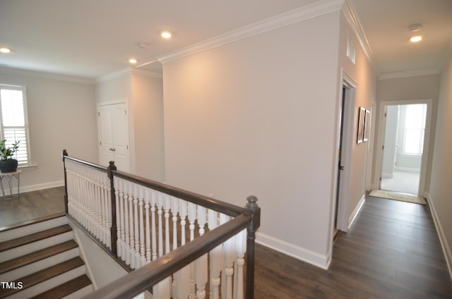 hall with crown molding, dark wood-style floors, an upstairs landing, and baseboards