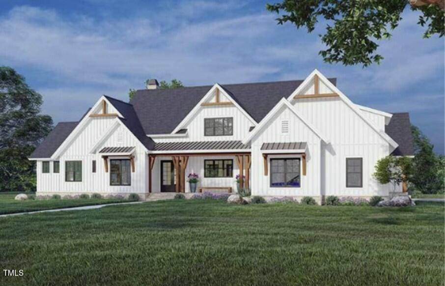 modern farmhouse style home with a standing seam roof, board and batten siding, metal roof, and a front yard