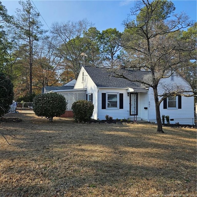 view of front of home featuring a front lawn and a shingled roof