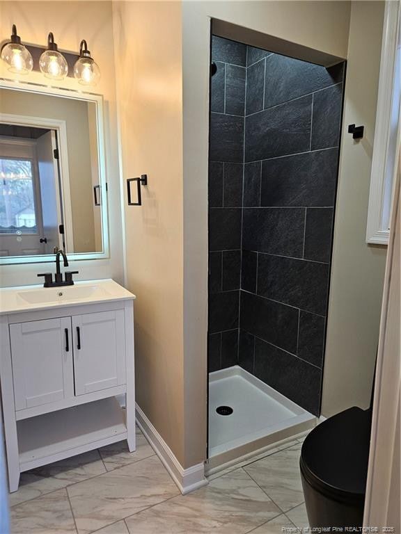 full bath featuring vanity, marble finish floor, and a stall shower