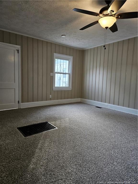 spare room featuring ornamental molding, baseboards, visible vents, and a textured ceiling