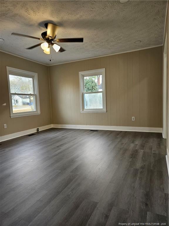 spare room with crown molding, a textured ceiling, dark wood-type flooring, and ceiling fan