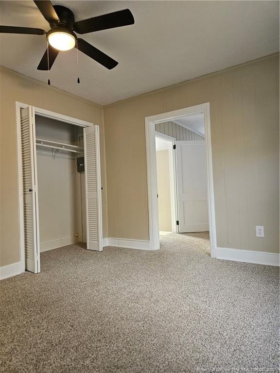 unfurnished bedroom with a closet, baseboards, ceiling fan, and carpet flooring