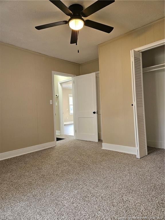 unfurnished bedroom featuring carpet flooring, a ceiling fan, a closet, and baseboards