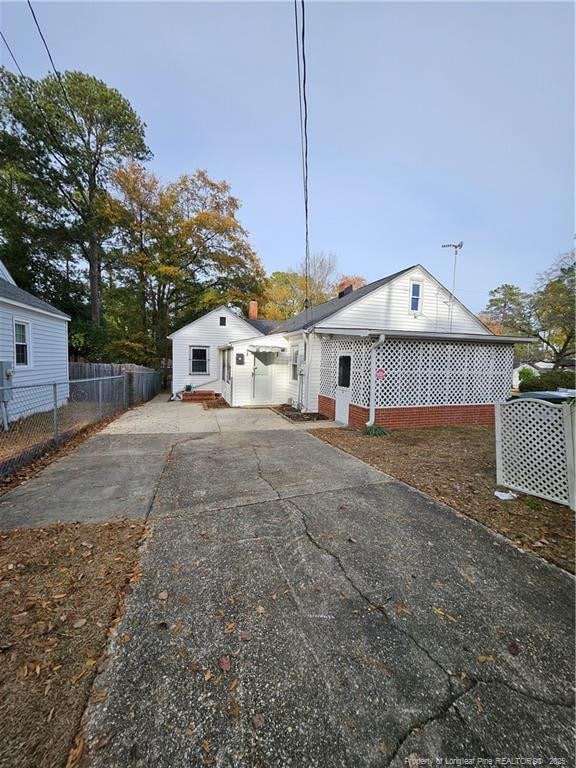 view of front of property with driveway and fence