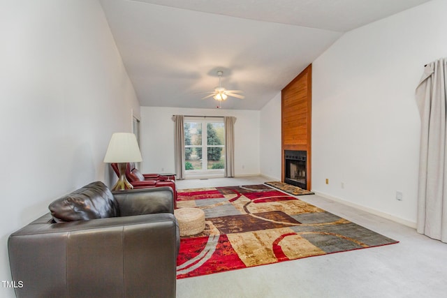 living area with a ceiling fan, carpet, a fireplace, baseboards, and vaulted ceiling