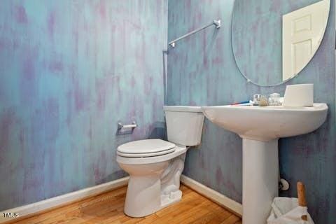 bathroom featuring toilet, baseboards, and wood finished floors