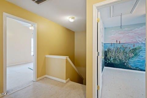 hallway with visible vents, an upstairs landing, carpet flooring, baseboards, and attic access