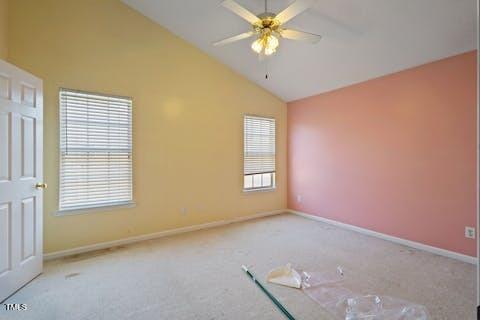 spare room with high vaulted ceiling, baseboards, carpet, and a ceiling fan