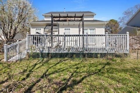 rear view of house with a wooden deck and a yard