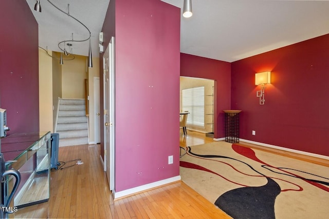 interior space featuring stairs, baseboards, and hardwood / wood-style floors