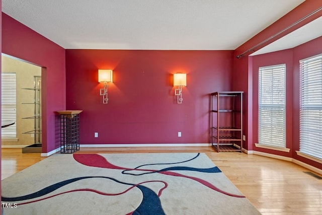 living area with visible vents, baseboards, and wood finished floors