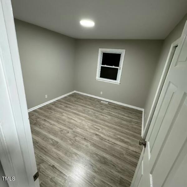 unfurnished bedroom with wood finished floors and baseboards