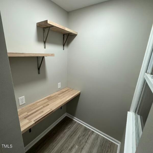 interior space featuring dark wood-type flooring and baseboards