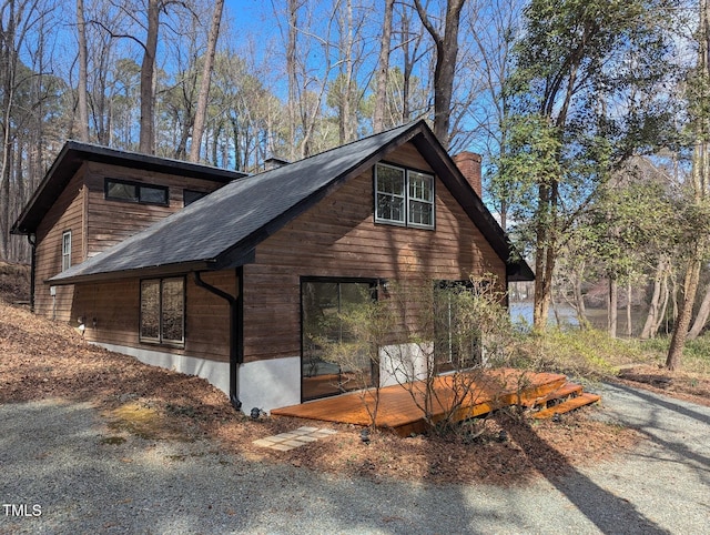 view of property exterior featuring roof with shingles and a chimney