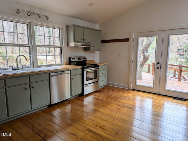 kitchen featuring gray cabinets, hardwood / wood-style flooring, a sink, appliances with stainless steel finishes, and lofted ceiling