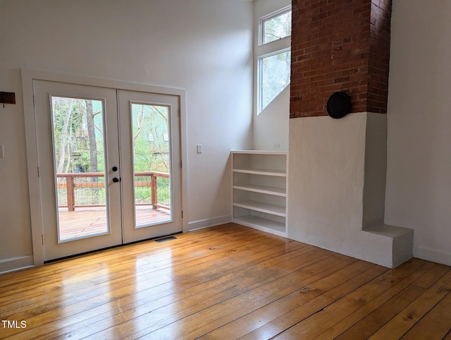 interior space with french doors, baseboards, visible vents, and hardwood / wood-style floors