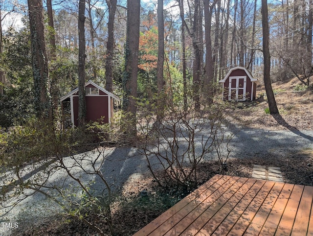 exterior space with an outbuilding, a forest view, and a storage shed